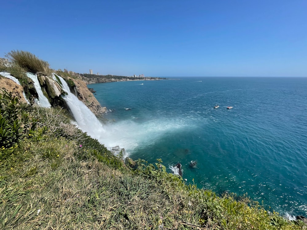 a body of water with rocks and grass on the side