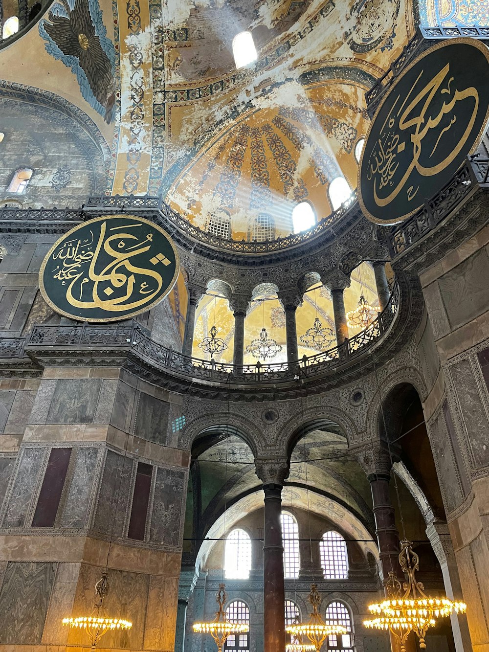a large ornate ceiling with arched windows with Hagia Sophia in the background