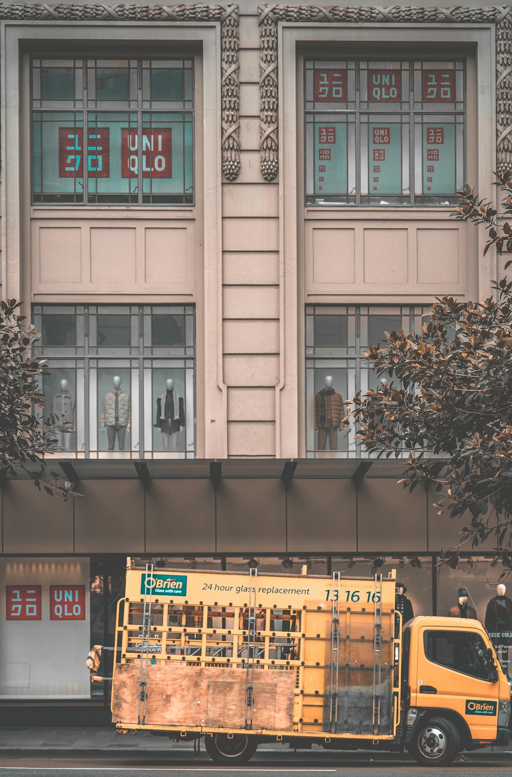 Ein gelber Lastwagen parkt vor einem Gebäude