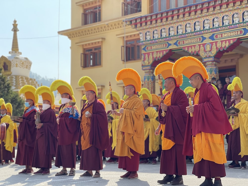 a group of people in robes and hats standing in front of a building