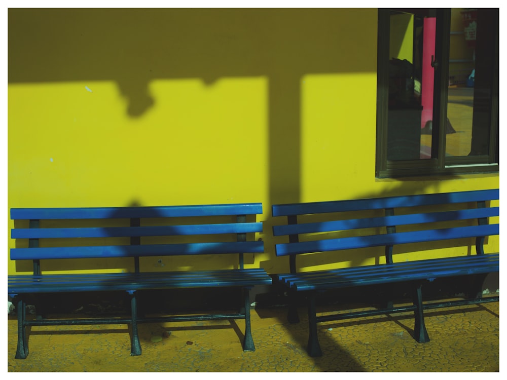 a couple of blue benches sit near each other