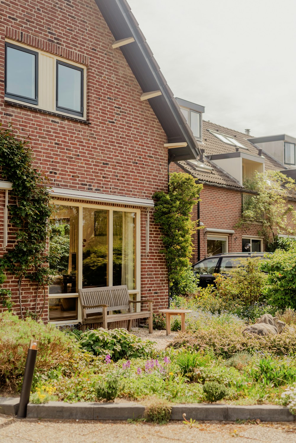 a brick building with a car parked in the driveway