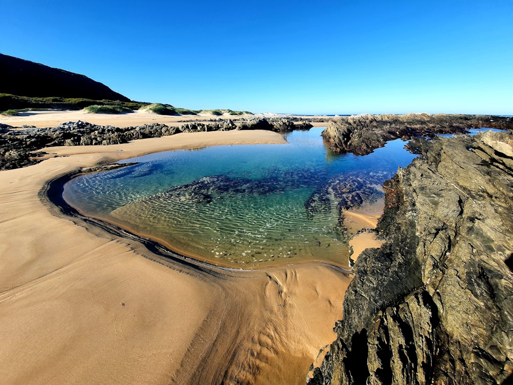 a body of water surrounded by rocky hills