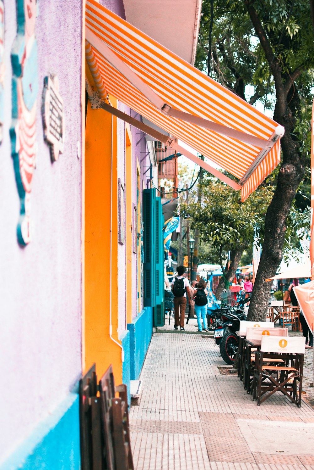 a sidewalk with a row of shops