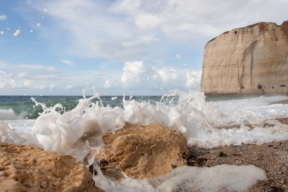 a large wave crashing into a rock