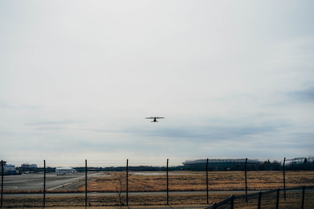 Un avión volando sobre un campo