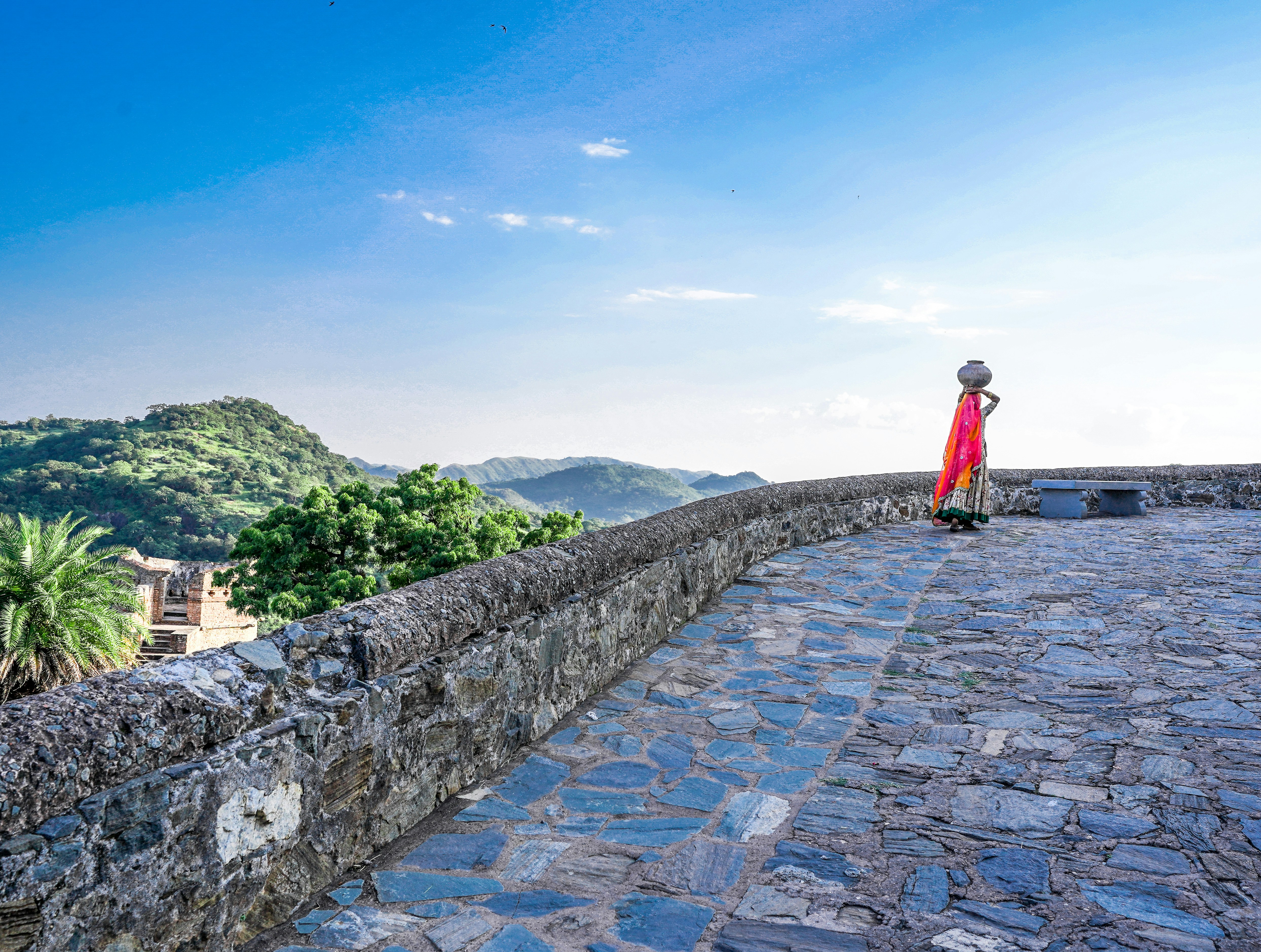 Person on stone wall at sunset