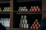 Rows of various canned and bottled food products lined up in a small grocery store aisle