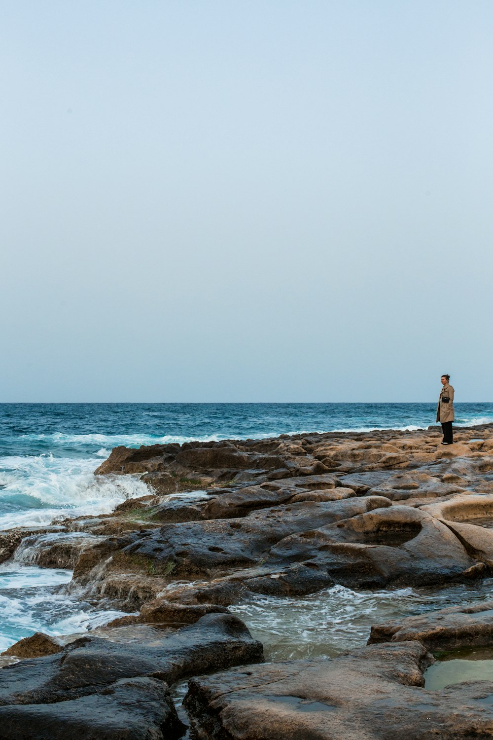 Un homme debout sur une plage rocheuse
