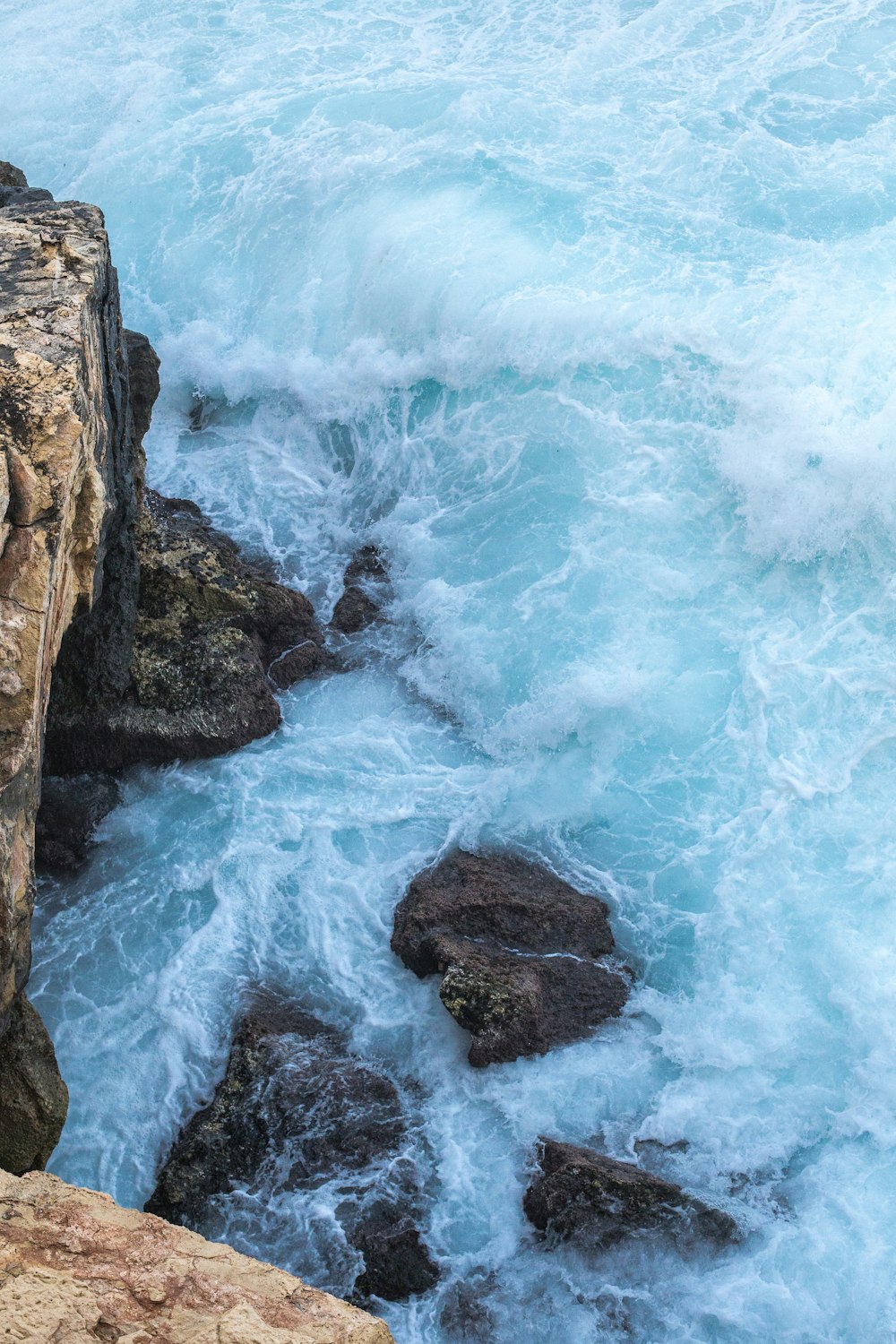 a rocky beach with waves crashing against it