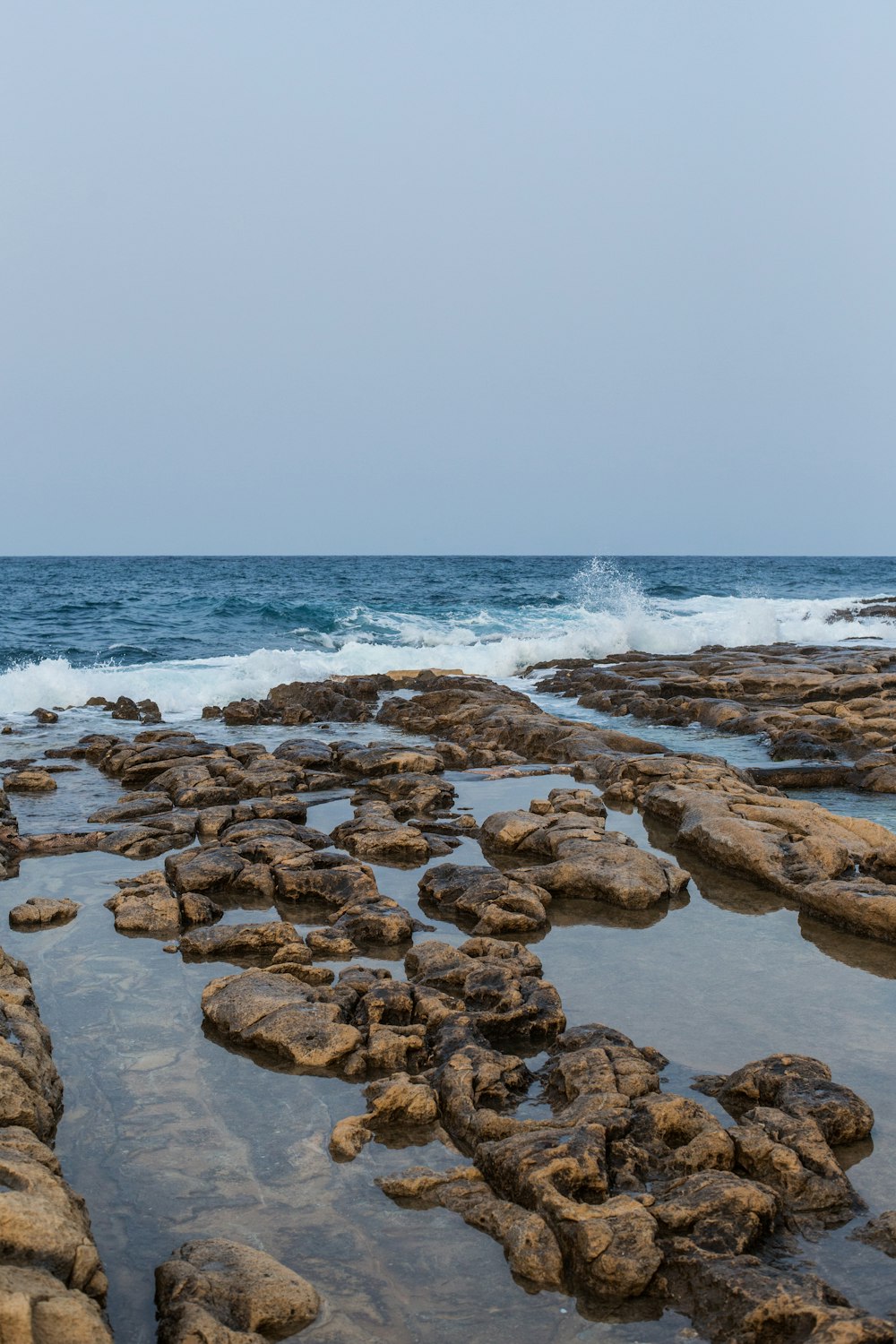 uma praia rochosa com ondas batendo