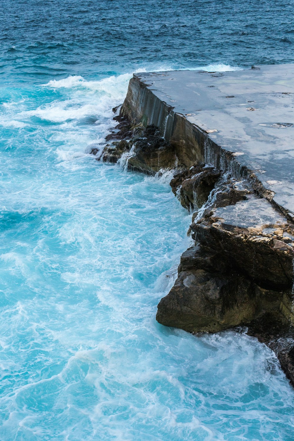 a rocky cliff next to the ocean