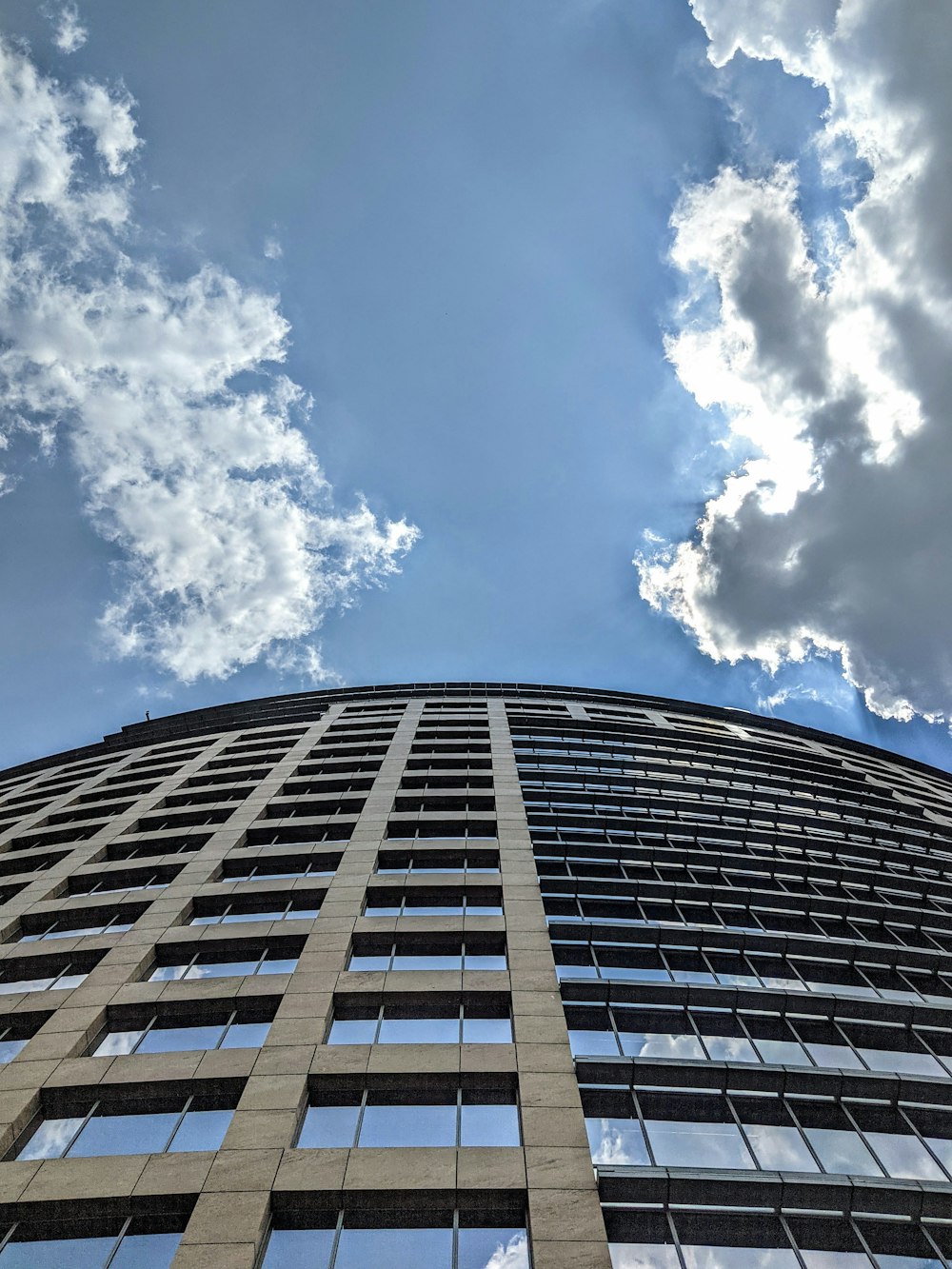 a tall building with clouds above it