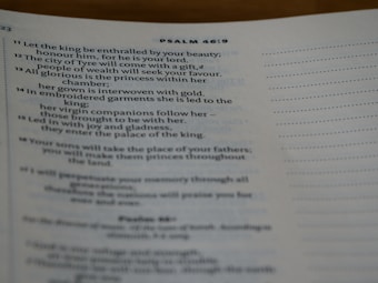 A close-up view of a page from a book, displaying text from Psalm 46:9. The text includes verses with references to topics like beauty, gifts, joy, and the palace of the king. The page has a cream-colored background with black printed text.