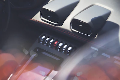 Close-up of a sleek luxury car dashboard with an elegant parfumée diffuser softly glowing.