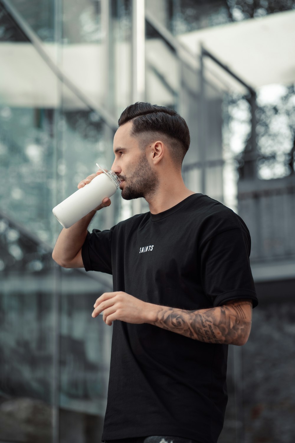 a man drinking from a white cup