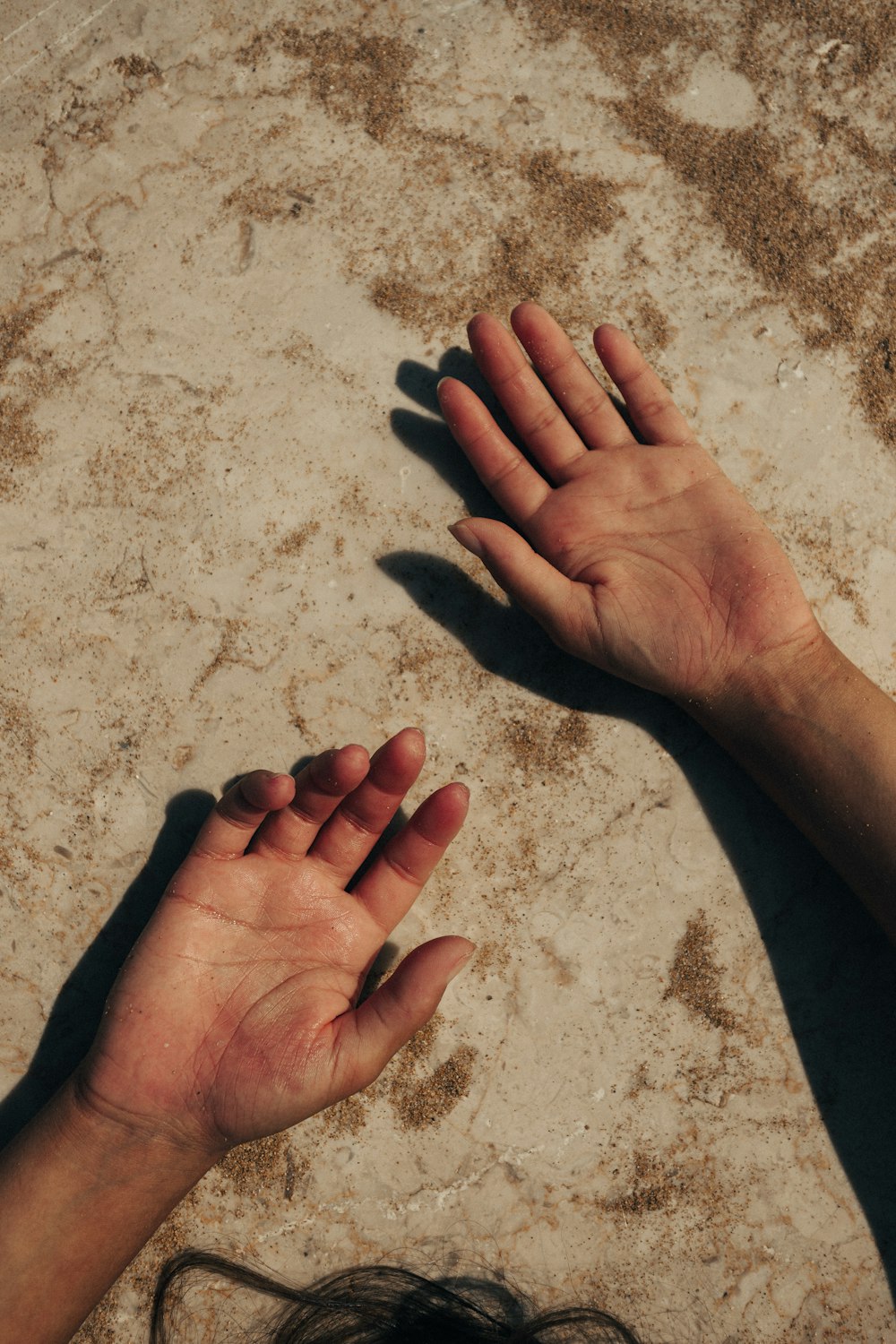 a pair of hands on a beach