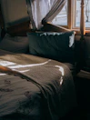 Natural light streaming through curtains onto a neat bedside table.
