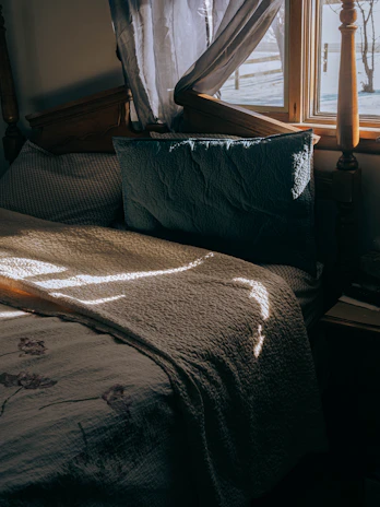 Close-up of a sparkling clean mattress surface with sunlight streaming through a window.