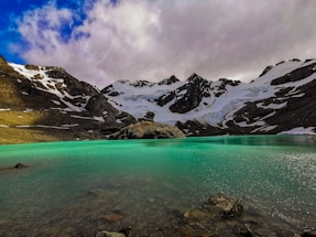 a body of water with mountains in the back
