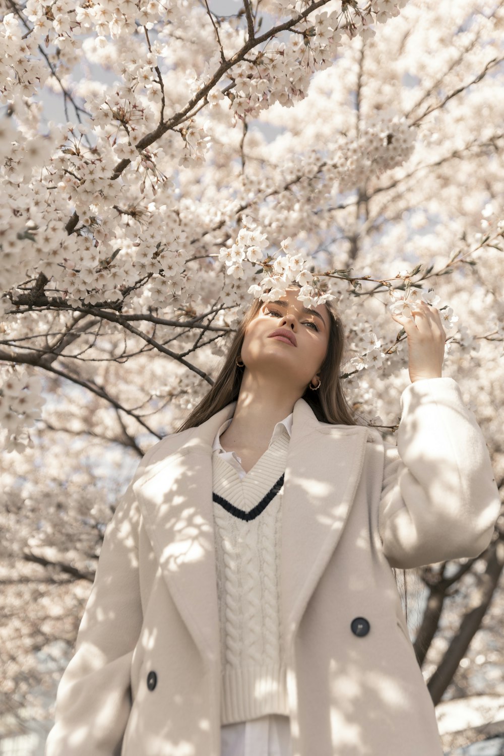 a woman standing under a tree