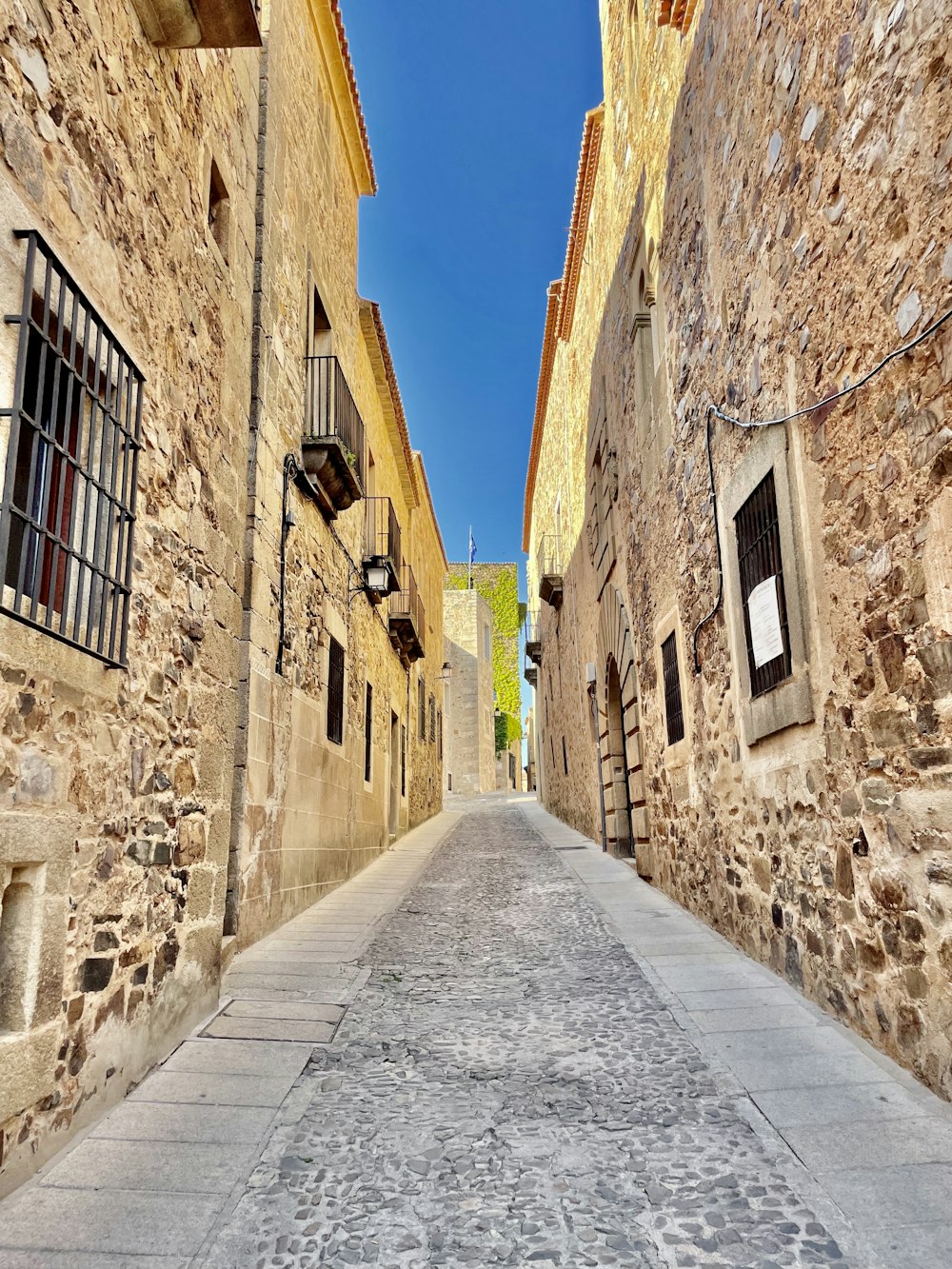 a narrow street between two stone buildings