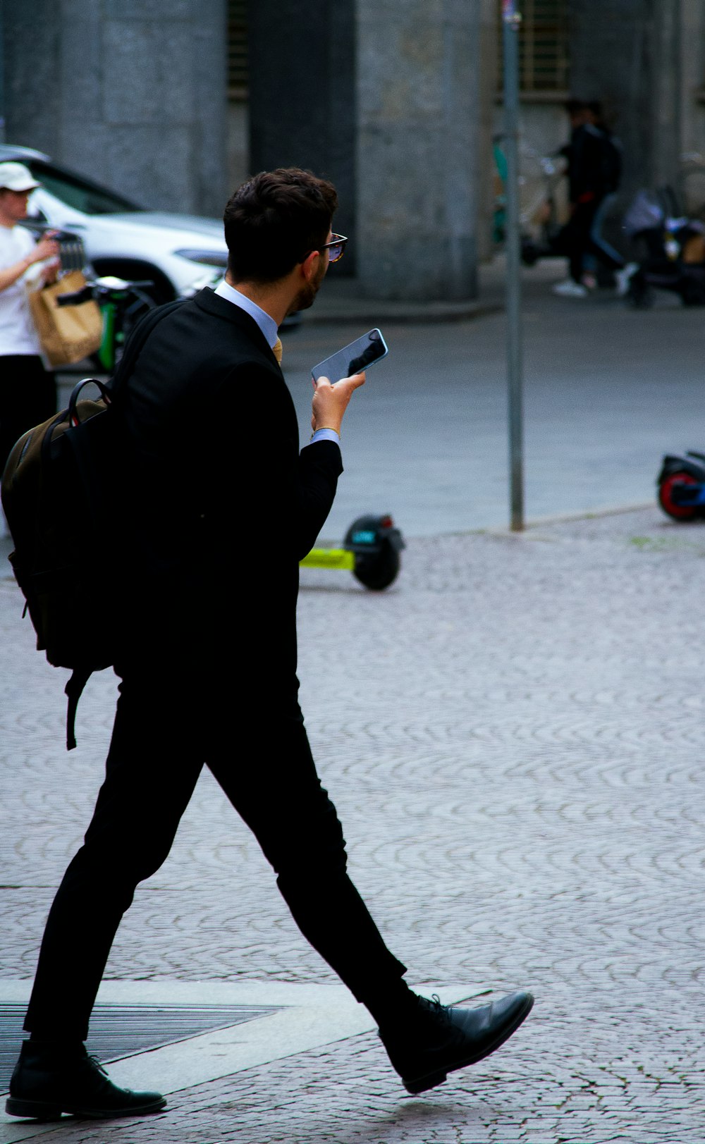 a person in a suit walking down a sidewalk