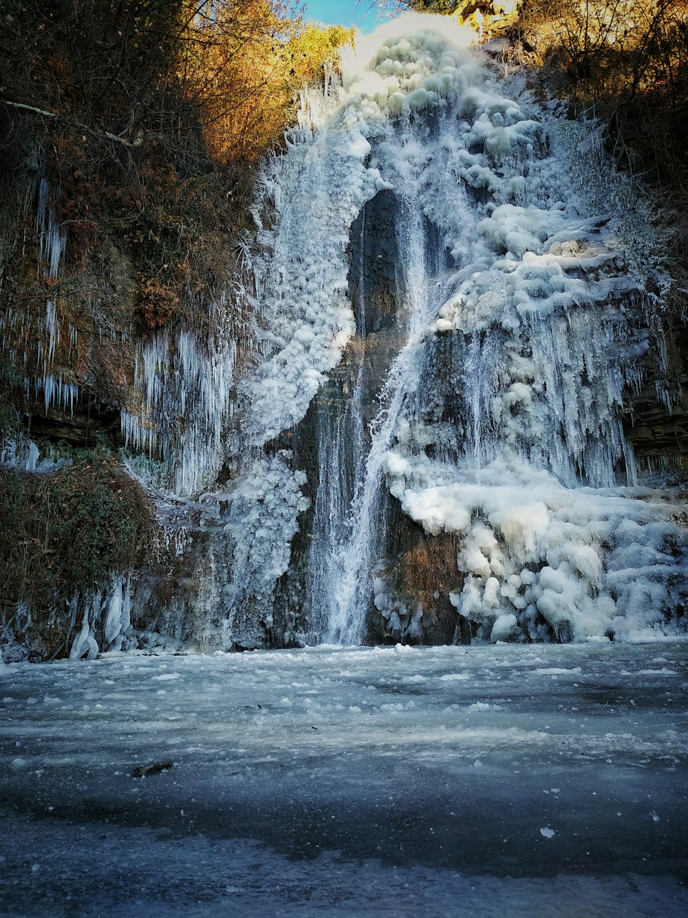 a waterfall with snow on the sides