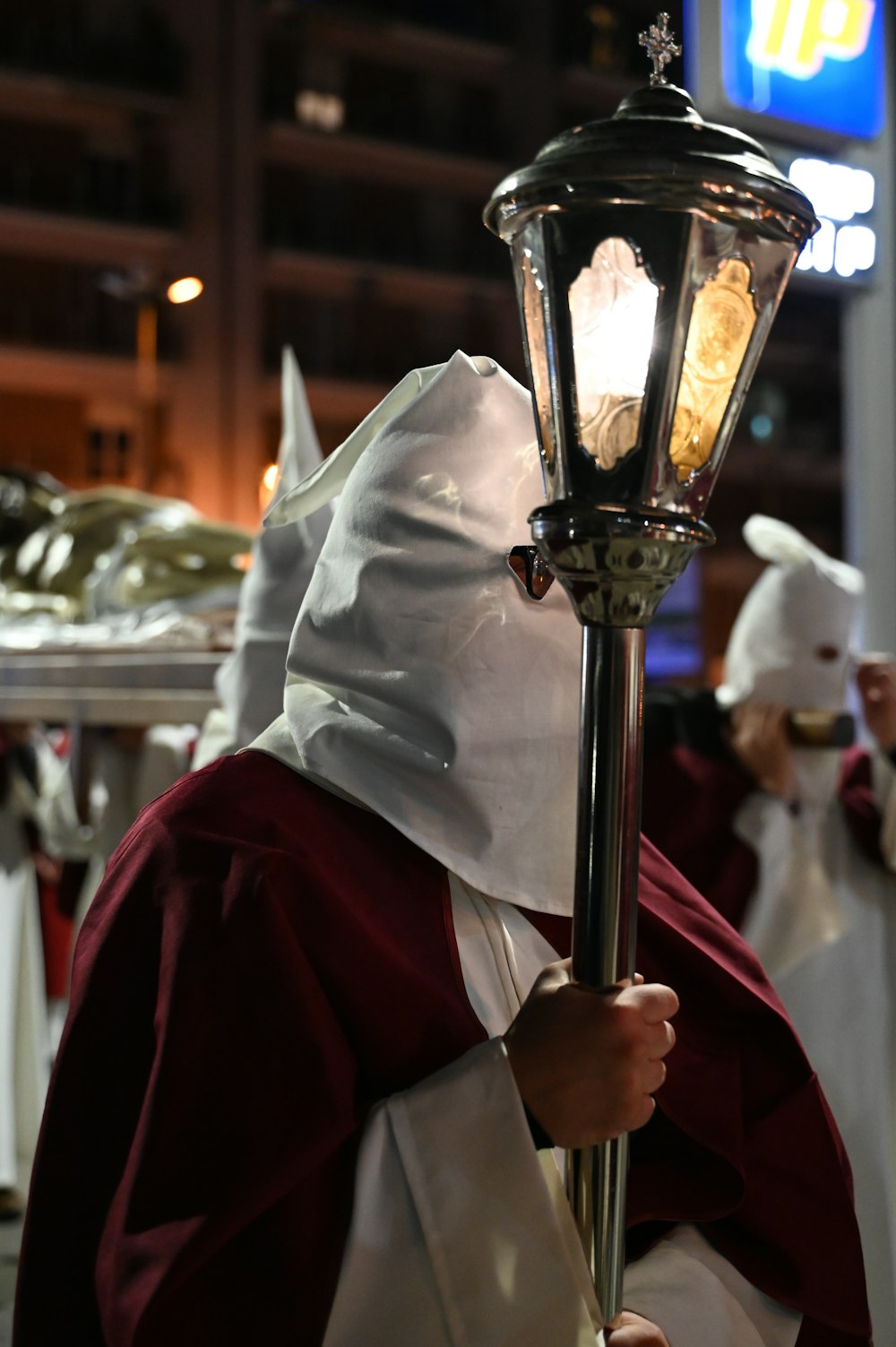 a person in a robe holding a lamp