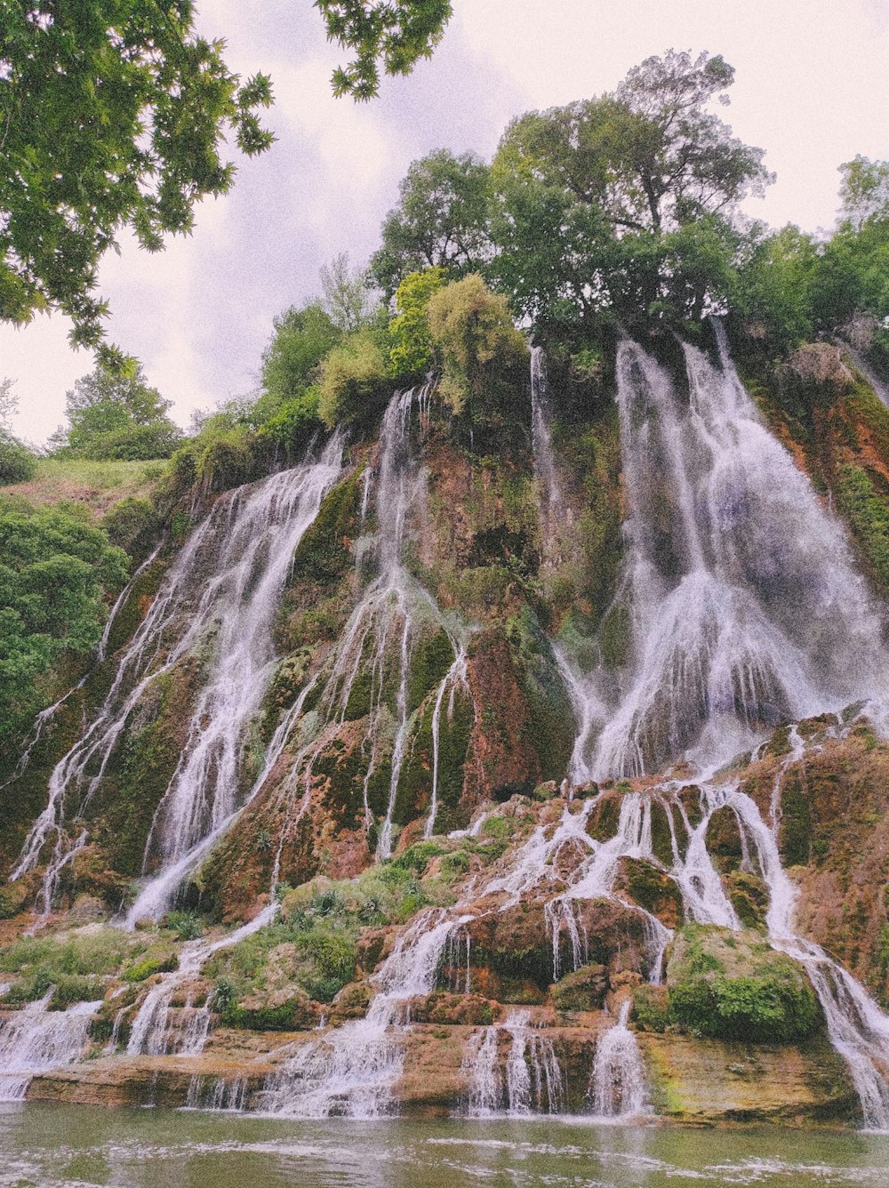 a waterfall with trees and rocks