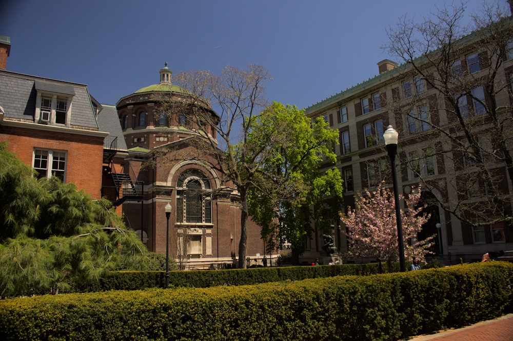 a large brick building with a clock tower in front of a house