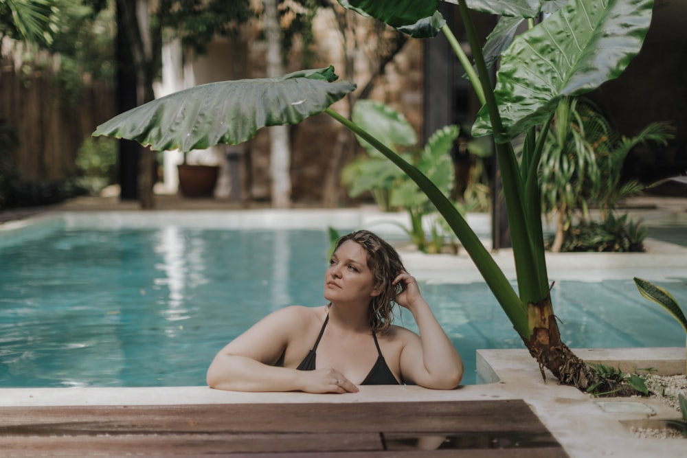 a woman sitting by a pool