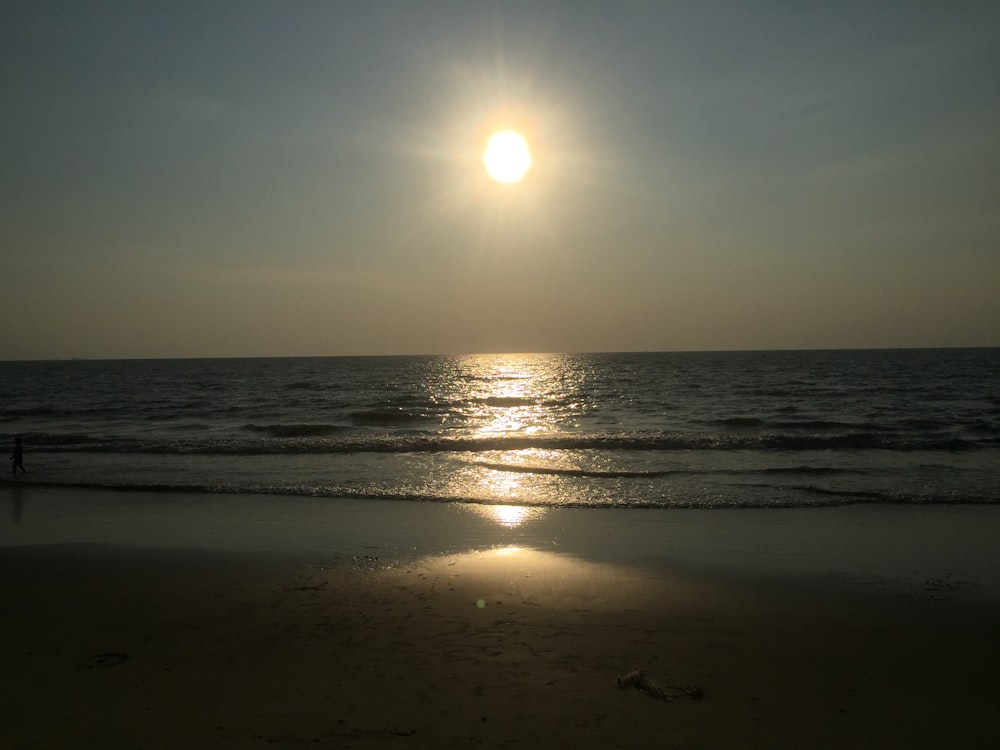 a beach with the sun setting