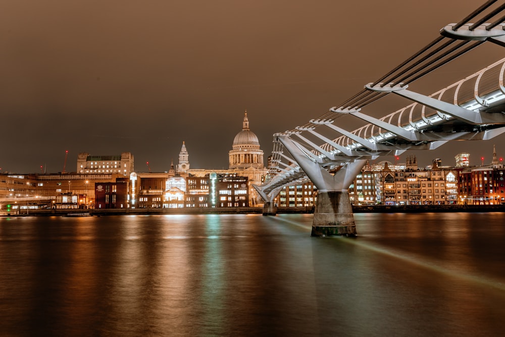 a bridge over a river with a city in the background