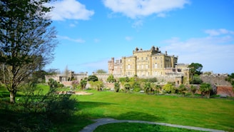 a large building with trees and grass with Culzean Castle in the background
