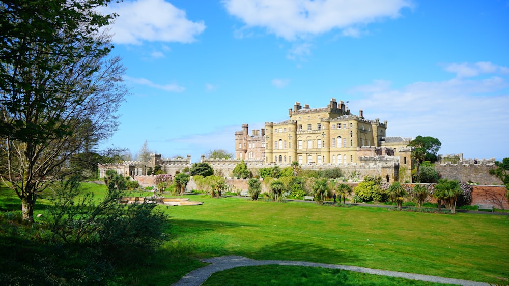 a large building with trees and grass with Culzean Castle in the background