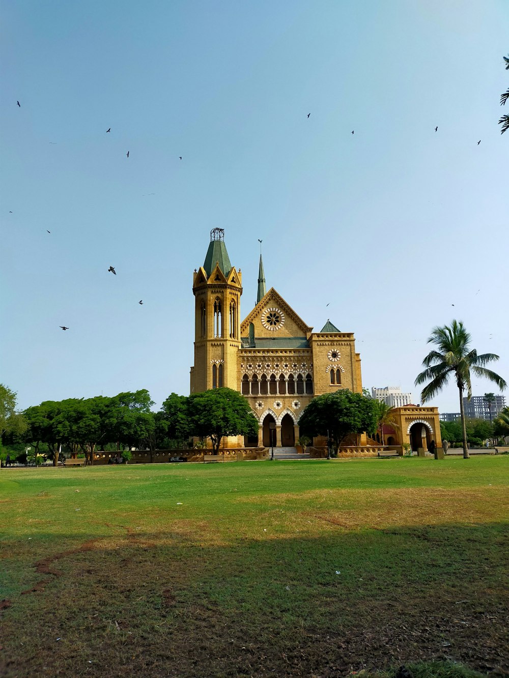 a building with a tower and trees in the front