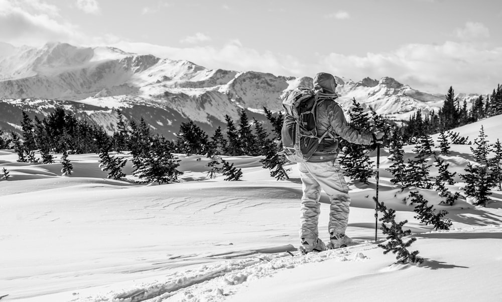 Ein Mann steht auf einem verschneiten Hügel