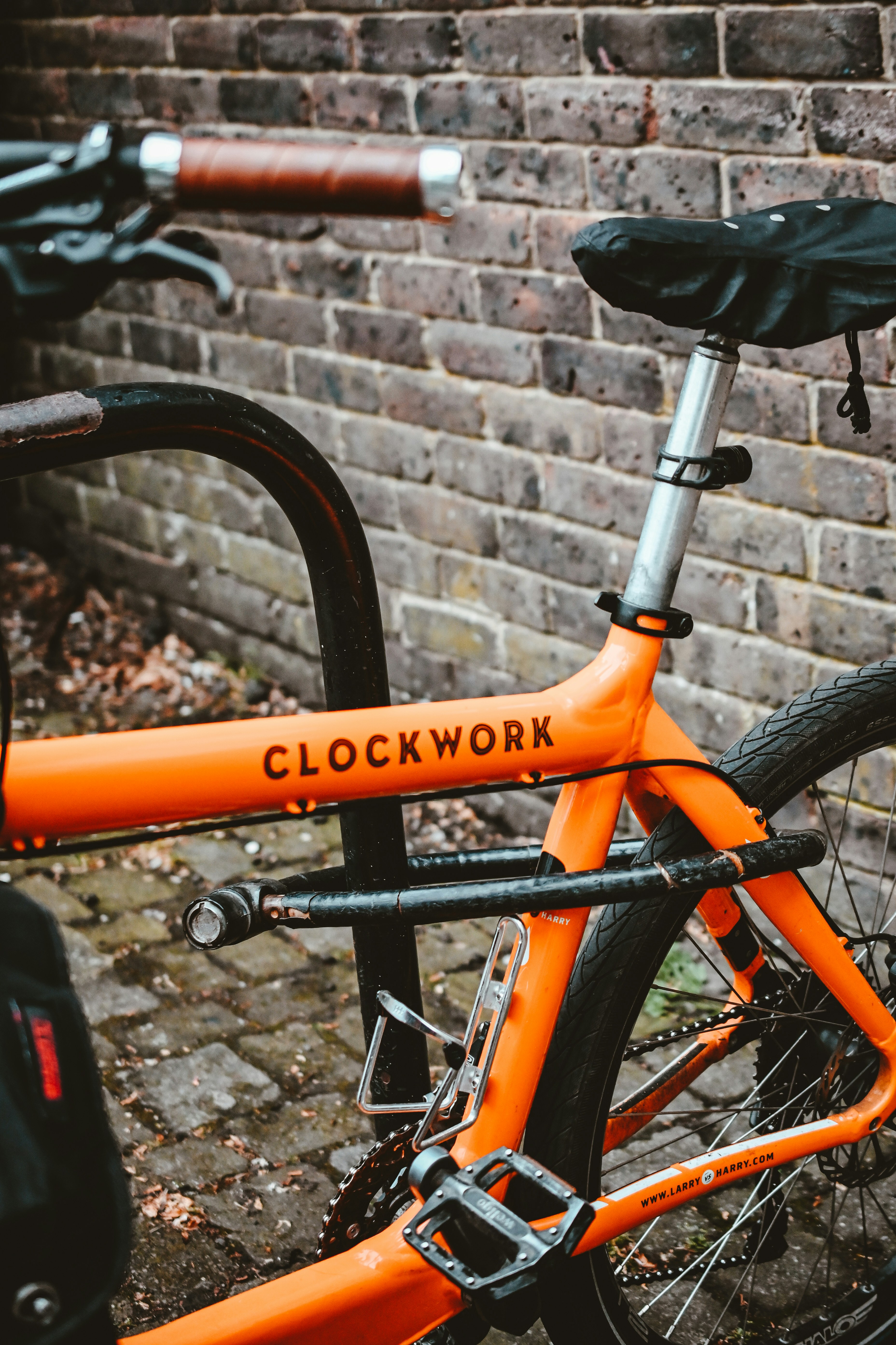 a bicycle parked in front of a brick wall