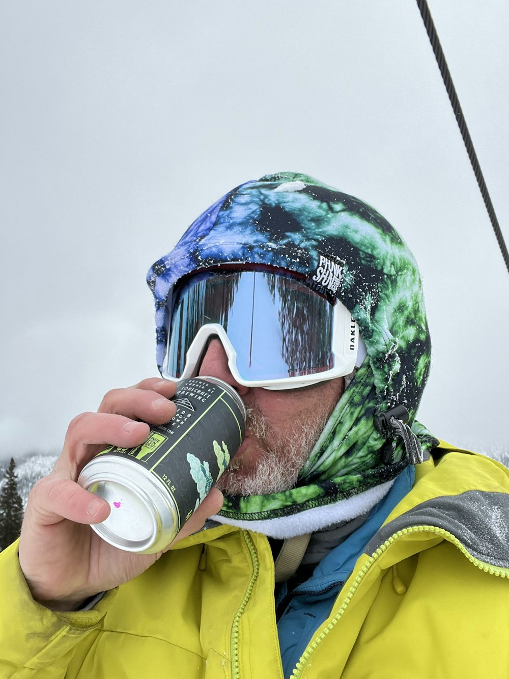 a person wearing a helmet and goggles drinking from a can