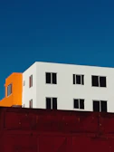 Exterior building facade with fresh white and orange paint highlighting the quality of our coatings.