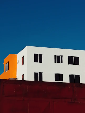 Exterior building facade with fresh white and orange paint highlighting the quality of our coatings.