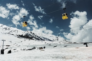 a ski lift going up a snowy mountain