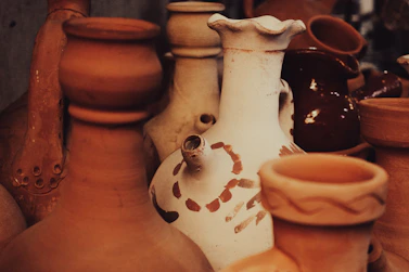 A beautifully arranged display of traditional pottery pieces with earthy tones and textures.