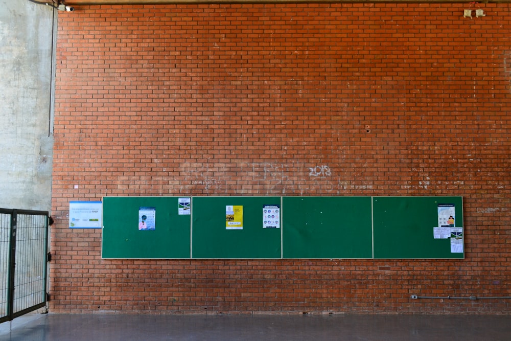 a brick wall with green signs on it