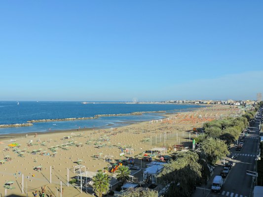 A beach with cars and trees — Rimini, Italy