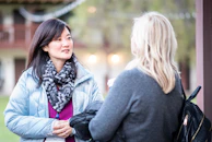 A candid moment of conversation between two members over coffee during a daytime meet-up.