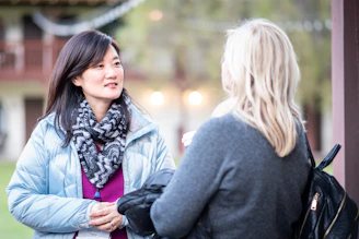 A candid moment of conversation between two members over coffee during a daytime meet-up.
