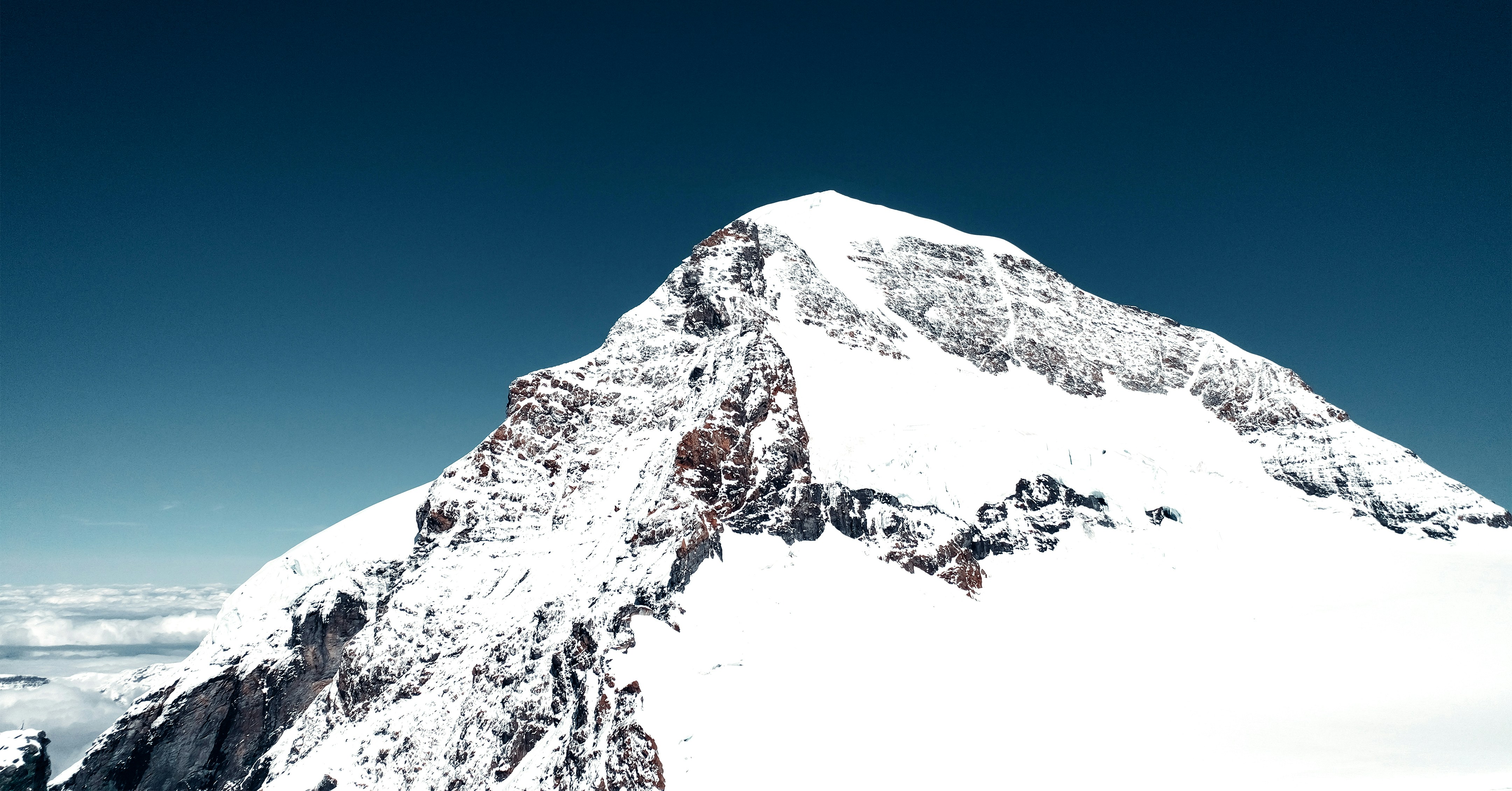 a snowy mountain with a blue sky