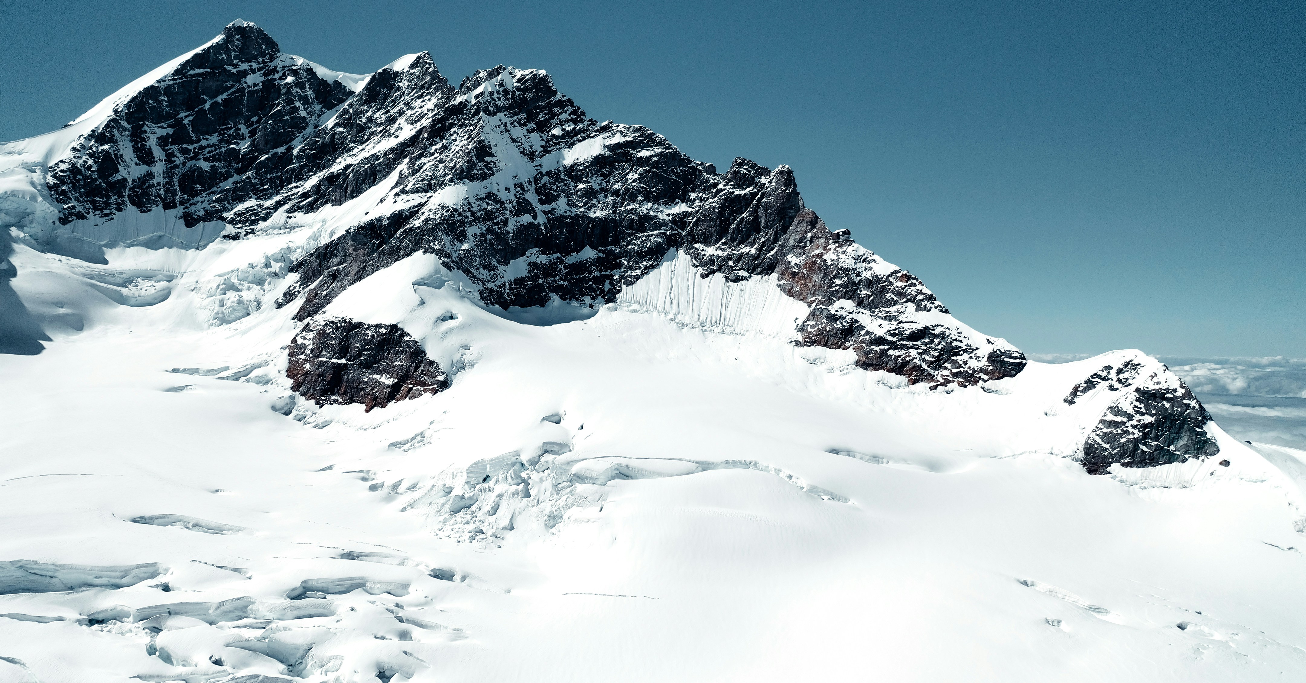 a snowy mountain with a blue sky